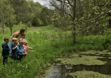 Children exploring a pond@2x